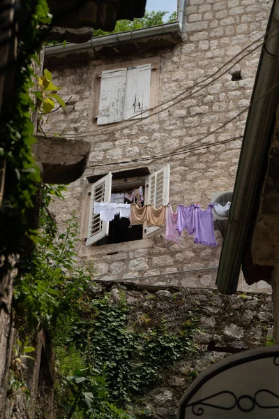 Ropa mojada se seca colgando de una cuerda cerca de la antigua casa de piedra en la ciudad europea — Foto de Stock