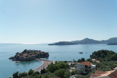 Karadağ'ın Adriyatik Denizi'nin panoramik görünümü. Ada Sveti Stefan ve arka planda dağlar.