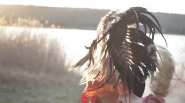 Kızılderili başlıklı güzel bir kız ve renkli makyajlı bir kostüm, ritüel dansında. Yüzüne yakın çekim..