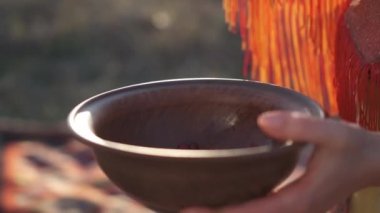 Amerikan yerlisi başlıklı ve kostümlü güzel bir kızın kırmızı böğürtlen döktüğü kilden bir kasenin kaybedilmesi.