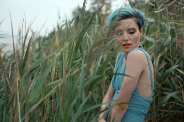 Sazlık çalılığında mavi mayolu güzel bir kızın portresi.