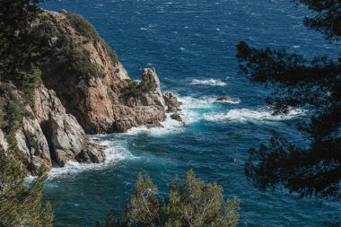 Rüzgarlı havada denize yakın kayalar.