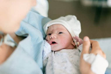 Hastanede yeni doğmuş bir bebeğin annesinin ellerinde ilk günü.