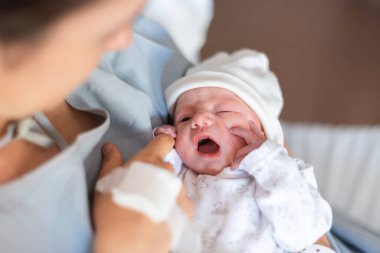 Hastanede yeni doğmuş bir bebeğin annesinin ellerinde ilk günü.