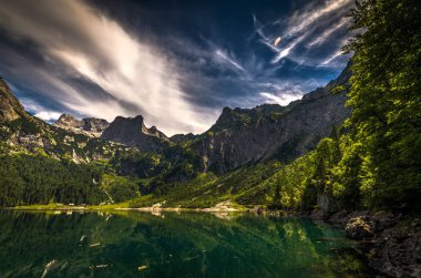 Doğal görünümünden Dachstein için Hinterer Gosausee dramatik mavi gökyüzü ve yeşil orman ile