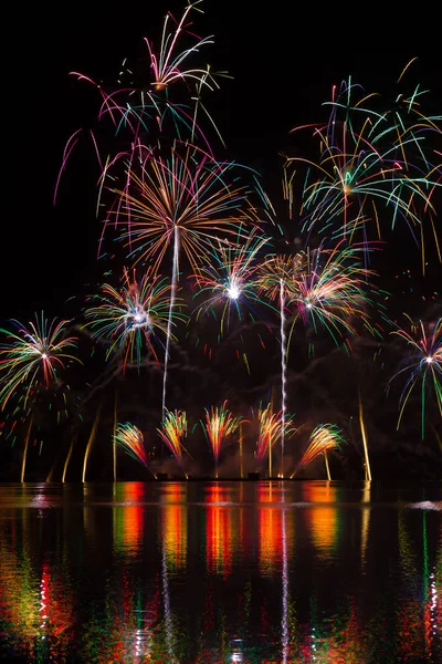 Magnificent rich fireworks over Brno\'s Dam with lake reflection on the surface