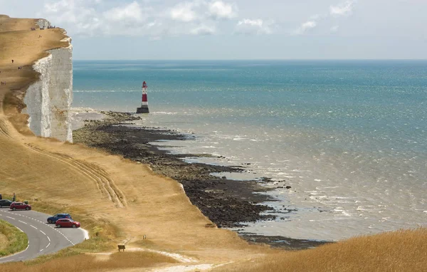 Road and lighthouse at Beachy Head near Eastbourne, East Sussex, England. With people.