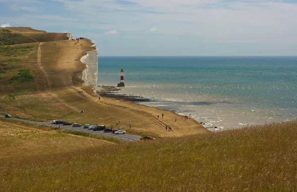 Road and lighthouse at Beachy Head near Eastbourne, East Sussex, England. With people.