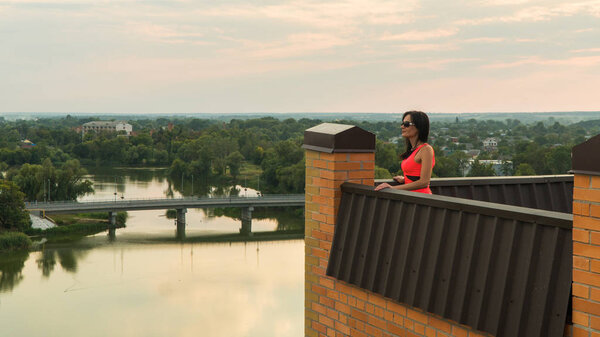 Девушка стоит на крыше дома. закат
.