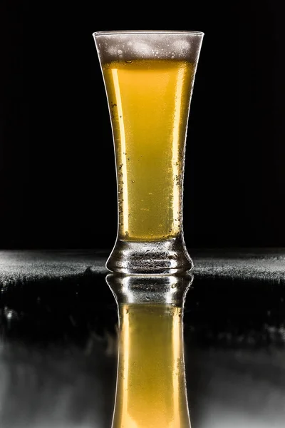 Beer. Cold Craft light Beer in a glass with water drops. Pint of Beer close up isolated on black color background. Border design.