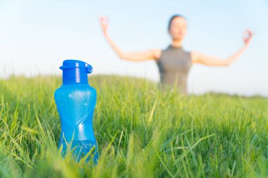 spor su şişesi. şişe çim üzerinde duruyor. sportif yaşam tarzı. kilo kaybı.