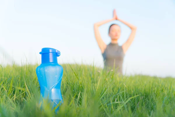 bottle of sports water. bottle stands on the grass. sporty lifestyle. weight loss.