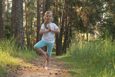 Çocuk ormanda yoga yapıyor..