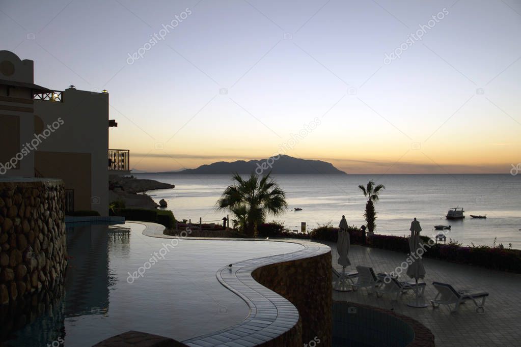 The swimming pool and sea with a view on Tiran island at luxury hotel at sunrise, Sharm el Sheikh, Egypt
