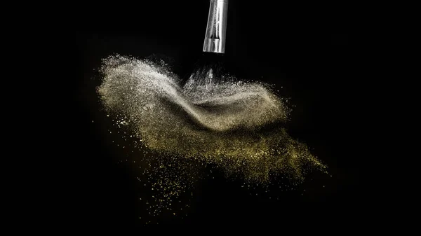 Escova cosmética com pó cosmético de ouro espalhando para ar de maquiagem — Fotografia de Stock