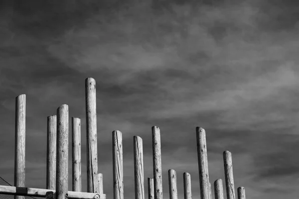 Streszczenie Projektu Drewniane Kolumny Tle Pochmurne Niebo Ciemne Monochromatyczne Tonu — Zdjęcie stockowe