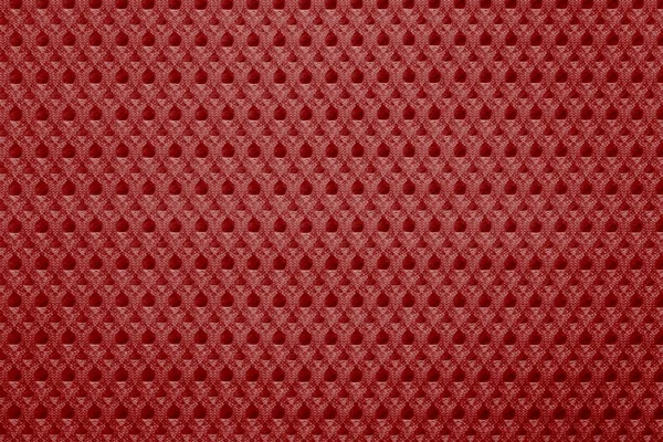 uniform corrugated texture of synthetic fabric or textile material of red color and closeup for a background