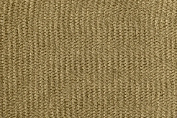texture of a knitted cloth or textile material closeup for a uniform background or for wallpaper of fashionable straw color