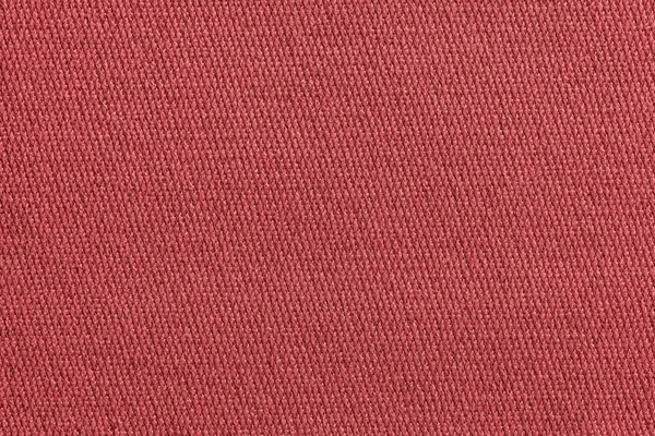 texture of a knitted cloth or textile material closeup for a uniform background or for wallpaper of fashionable scarlet color