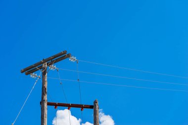 eski ahşap sütunlar için boş bir arka plan mavi gökyüzünün üzerinde güç hattı