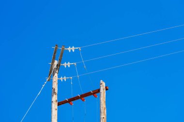 eski ahşap sütunlar için boş bir arka plan mavi gökyüzünün üzerinde güç hattı