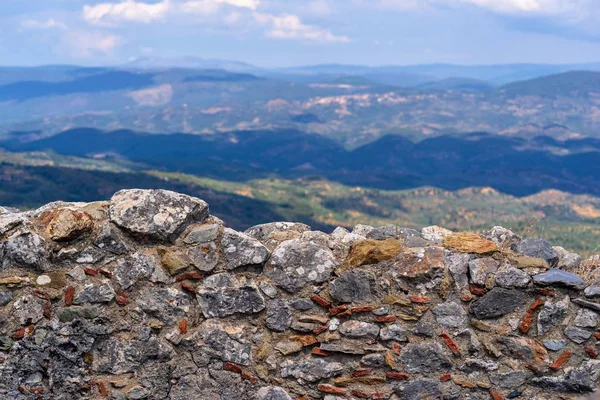 eski ve antik taş duvar ile bulutlu gökyüzü ve dağ tepeleri ufukta bir manzara arka plan karşı kapatın