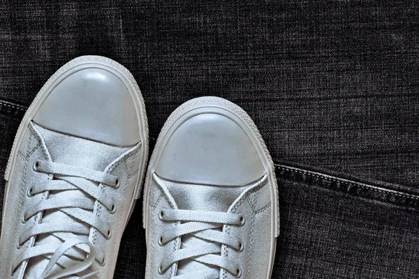 Modieuze gym schoenen close-up op de achtergrond van een jeans — Stockfoto