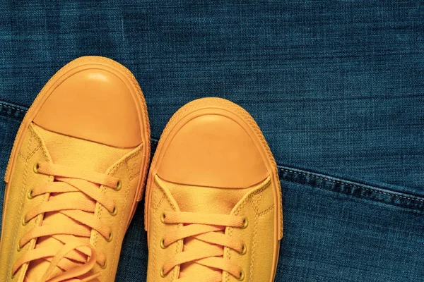 Sapatos de ginásio na moda close-up em um fundo de calça — Fotografia de Stock
