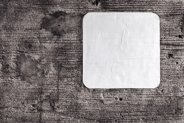 Foglio vuoto di carta è incollato su un vecchio muro di cemento — Foto Stock