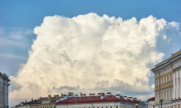Grote witte wolk over daken van huizen — Stockfoto