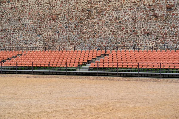 Reihen mit Stühlen für das Publikum vor dem Hintergrund einer Steinmauer im Freien — Stockfoto