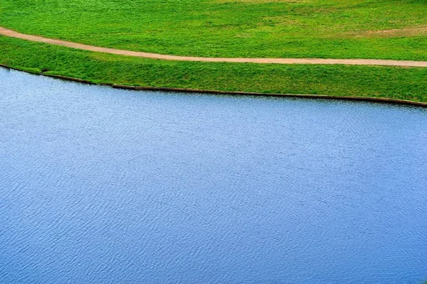 The combined texture of blue water and green grass in nature. — Stock Photo, Image