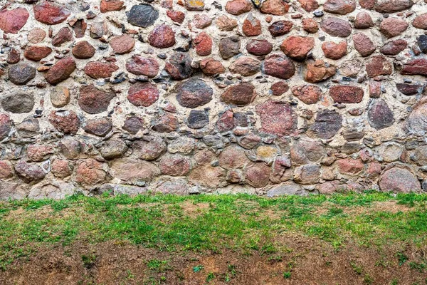 Antiguo muro de piedra y suelo con hierba . —  Fotos de Stock