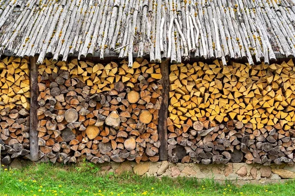 Trä ved i en stapel under ett kapell. — Stockfoto