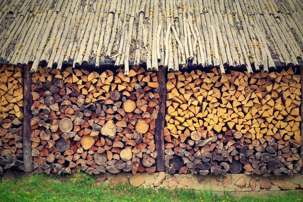 Trä ved i en stapel under ett kapell. — Stockfoto