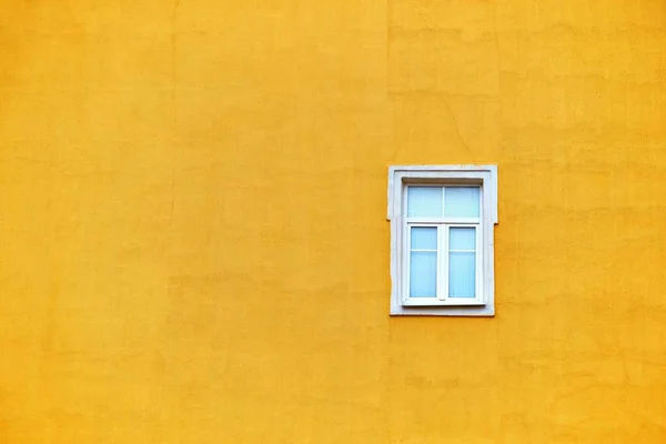 Uma janela em uma parede amarela vazia — Fotografia de Stock