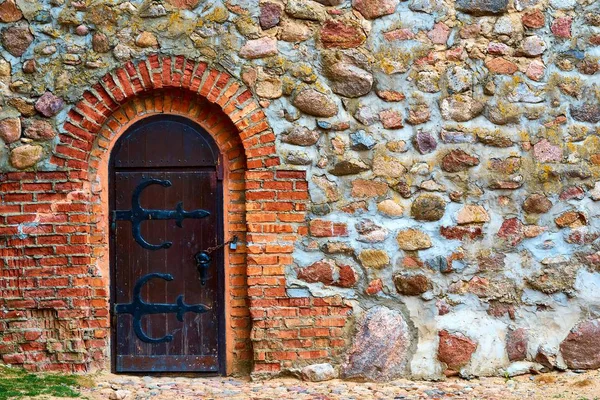 Antica parete in pietra con porta in legno — Foto Stock