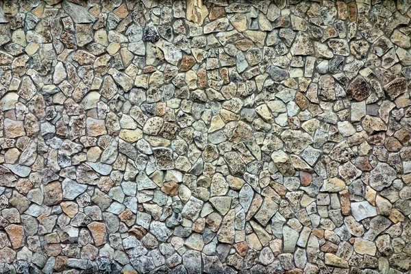 Textured spotted surface of the background is covered with stones — Stock Photo, Image