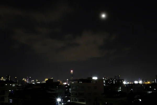 Cidade pacífica à noite com o céu e a lua brilhante — Fotografia de Stock