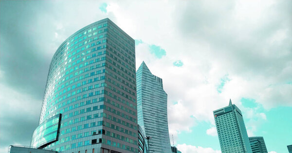 Modern urban architecture background. Glass wall facade with cloud sky reflection. Skyscraper, Business Center, Bottom View. Glass metropolis outside in pink with highlights