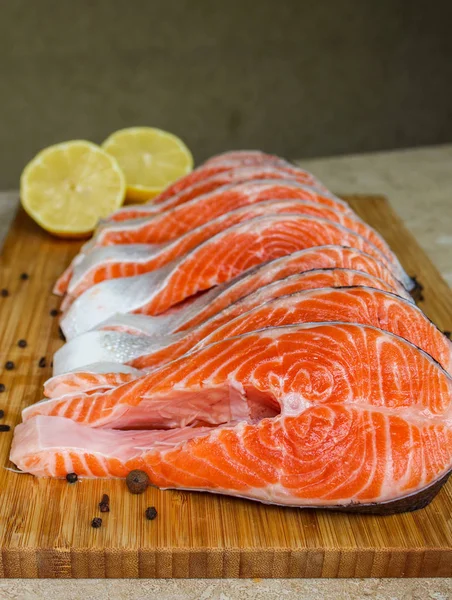 Red fish steak, freshly cut with peel on a cutting board — Stock Image Red Fish Steak Freshly Cut Peel Cutting Board Royalty Free Stock Images