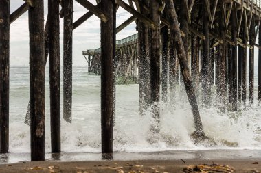 San Simeon, Kaliforniya, ABD iskelenin altındaki adamların kırma dalgalar