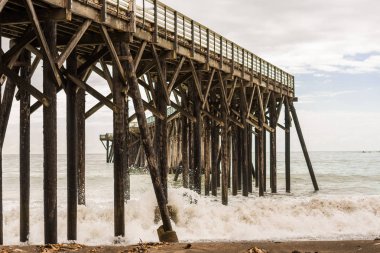 San Simeon, Kaliforniya, ABD iskelenin altındaki adamların kırma dalgalar