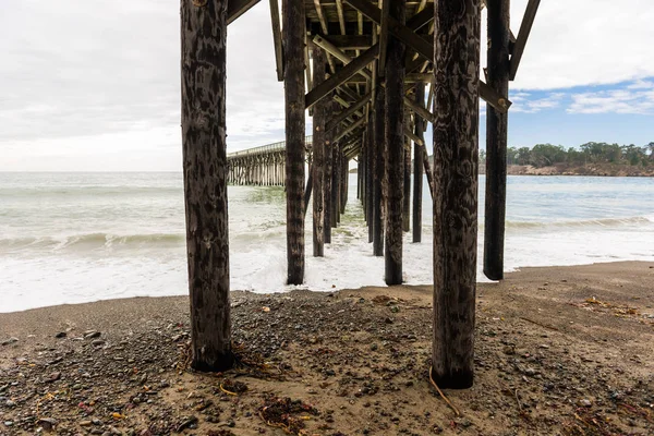 Olas rompiendo en los postes bajo el muelle de San Simeón, California, EE.UU. —  Fotos de Stock