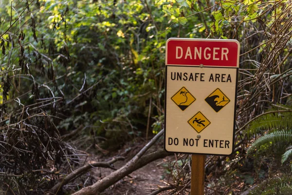 Señal de advertencia en uno de los senderos debido al peligro de deslizamientos de tierra, mareas o caídas en el sur de Oregon, EE.UU. — Foto de Stock