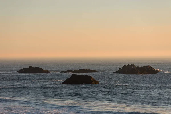 Islets protruding in the Pacific Ocean on a beach in Southern Oregon, USA — Stock Photo, Image