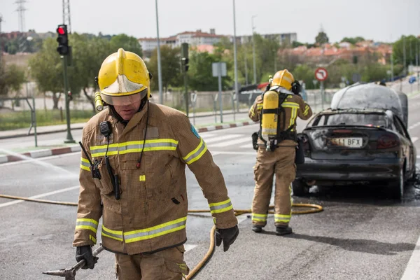 Caceres, extremadura, spanien - 24. April 2018: Feuerwehrleute löschen ein Auto, das auf einer Straße in caceres gebrannt hat. — Stockfoto