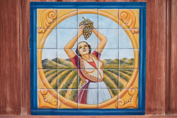 Peinture de femme cueillant des raisins dans un vignoble dessiné sur des tuiles . — Photo