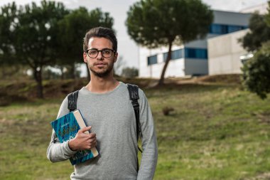Bilgisayar bilimi genç öğrenci Politeknik okul binalarından birinin yanında bir robotik kitap ile pozlar