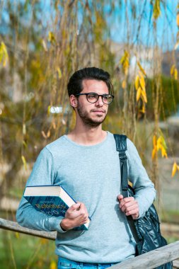 Bilgisayar bilimi genç öğrenci Politeknik okul binalarından birinin yanında bir robotik kitap ile pozlar